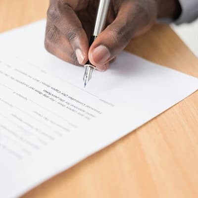 A hand signing an important document