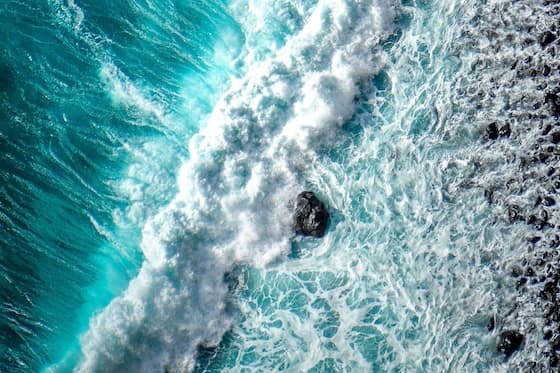 Tidal sea wave blue and white with a rock